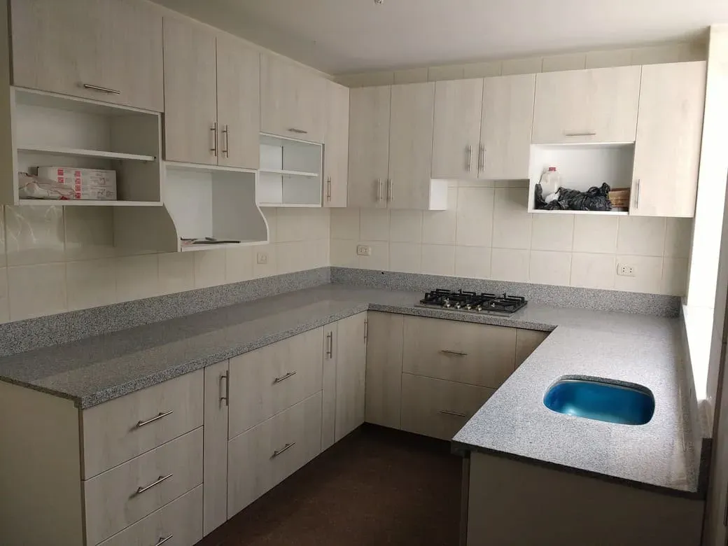 Cocina de melamina color claro con encimera de granito